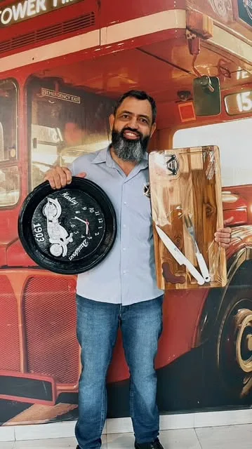 Barbeiro da Tegon em frente ao mural do ônibus vermelho